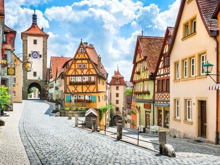 Beautiful postcard view of the famous historic town of Rothenburg ob der Tauber on a sunny day with blue sky and clouds in summer, Franconia, Bavaria, Germany.