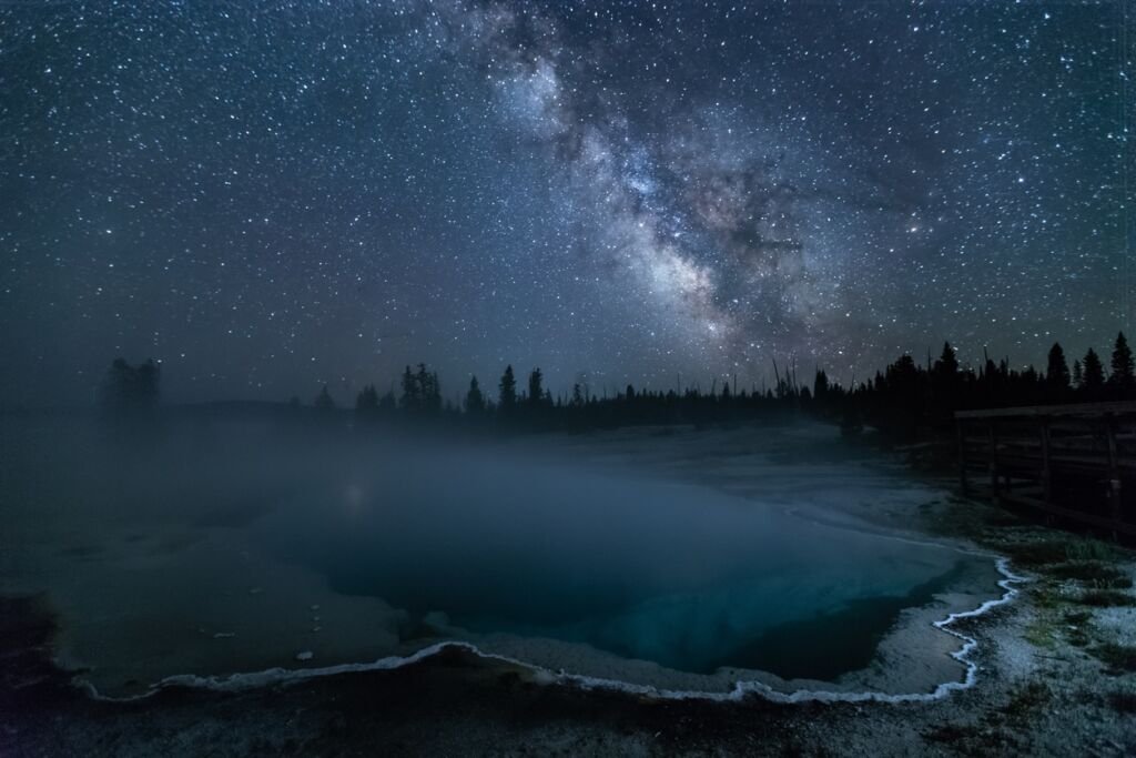 This is a picture of Black Pool at night with mikyway and stars at Yellowstone National Park, Idaho, USA.