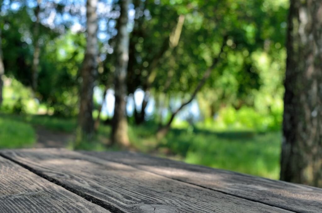Wooden table on a background of green trees.