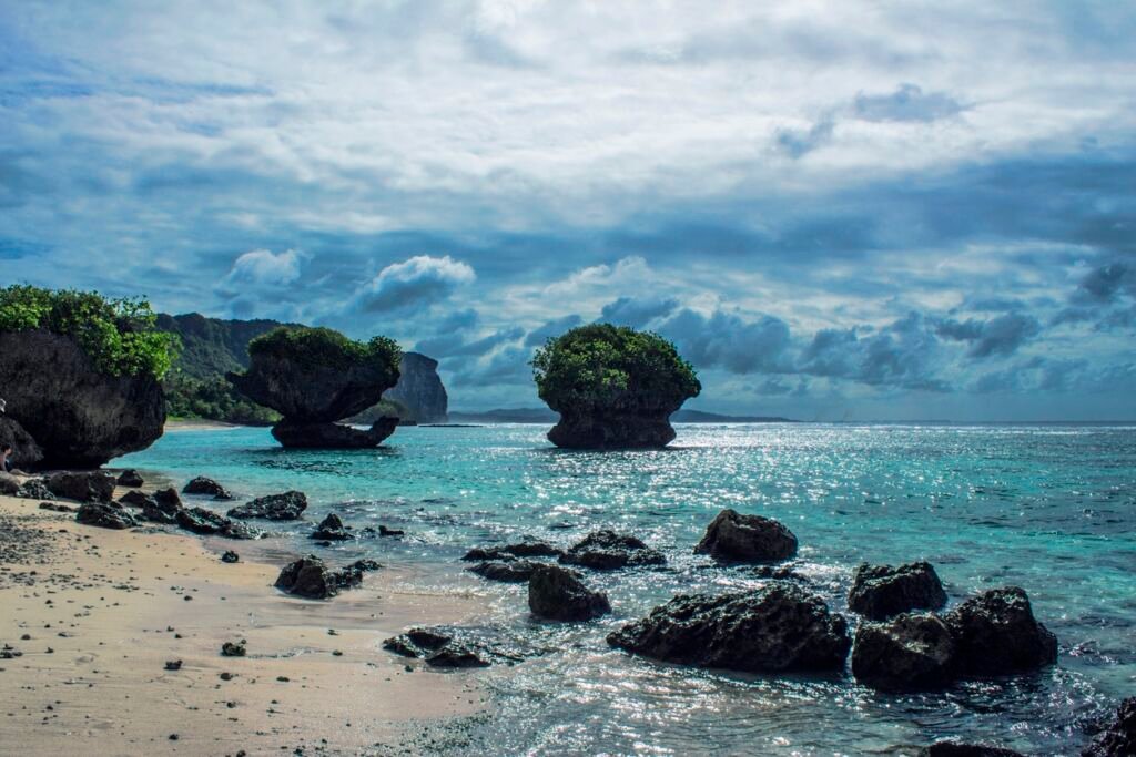 A picture of a large rock in a beautiful ocean at Tanguisson Beach in Guam.