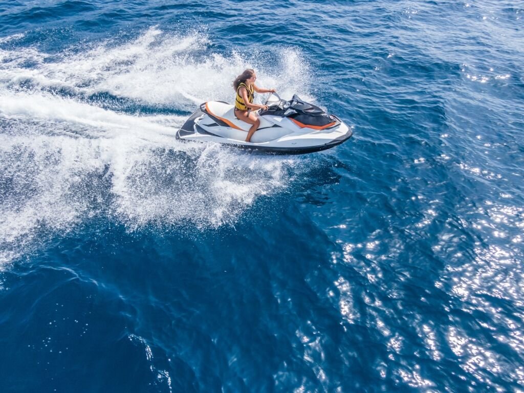 Aerial view of jet skier in blue sea. Jet ski in turquoise clear water racing stock photo