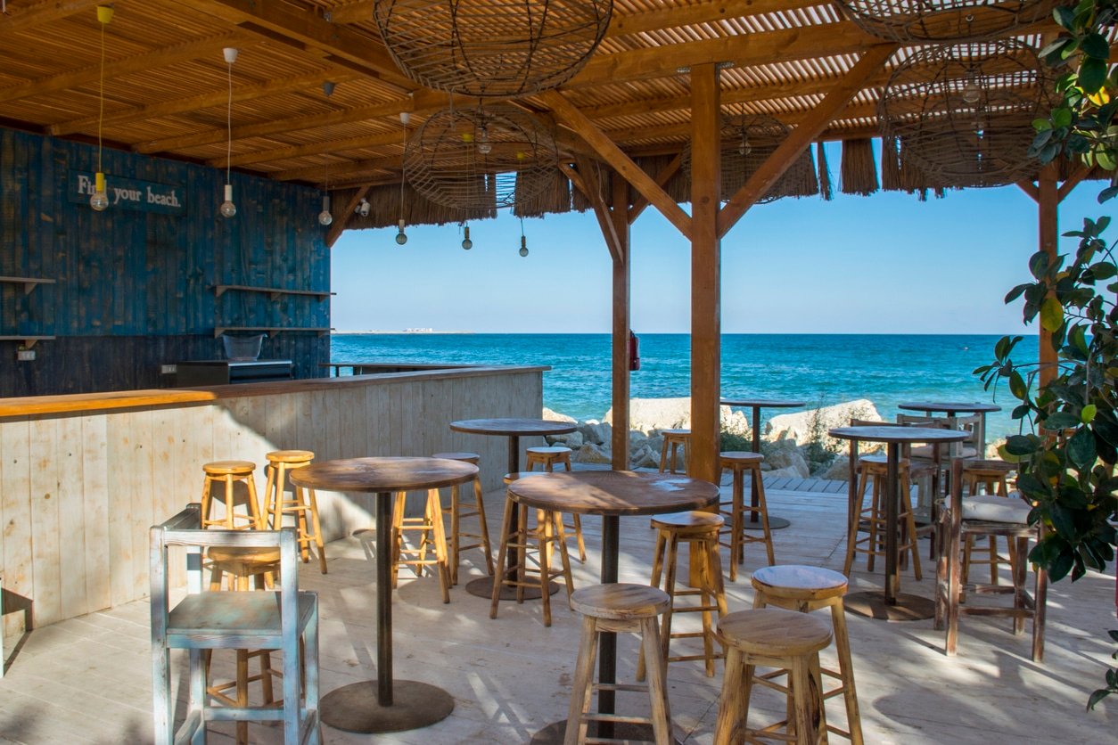 beach bar with stools and view of the ocean