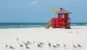 Red wooden lifeguard hut on an empty beach