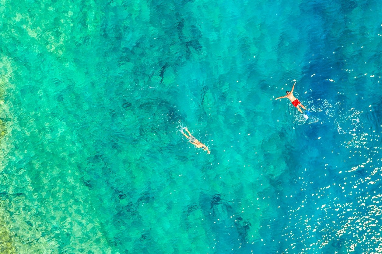 Aerial drone view of swimming men