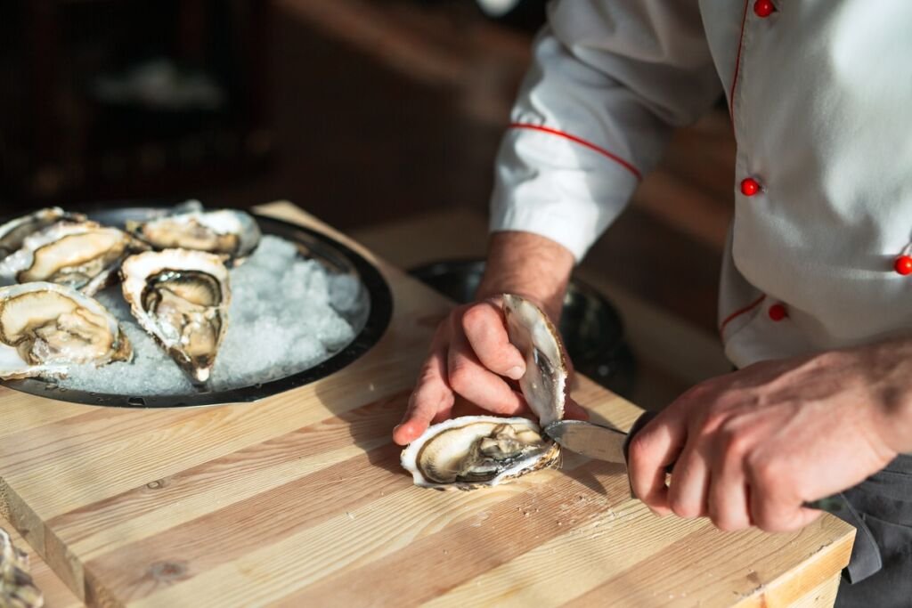 Chef opens oysters in the restaurant.