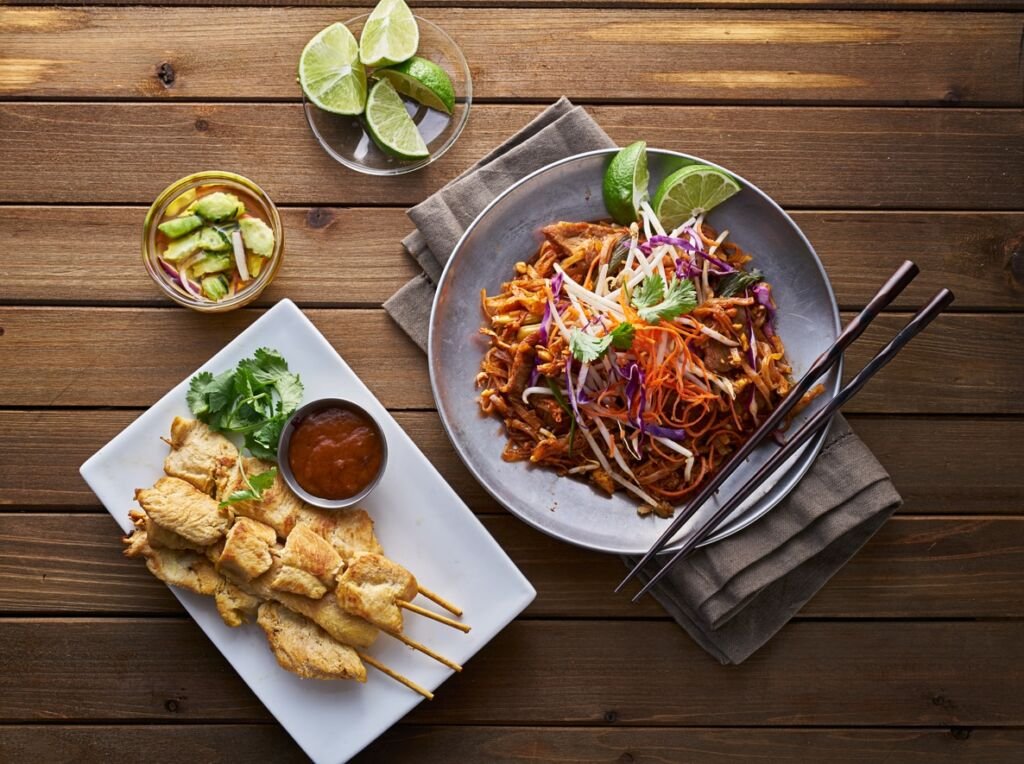 beef pad thai and chicken satay dinner viewed from above