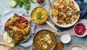 Indian/Pakistani cuisine dinner: tandoori chicken, biryani, red lentil curry dal with rice naan, palak paneer and basmati rice on wooden background