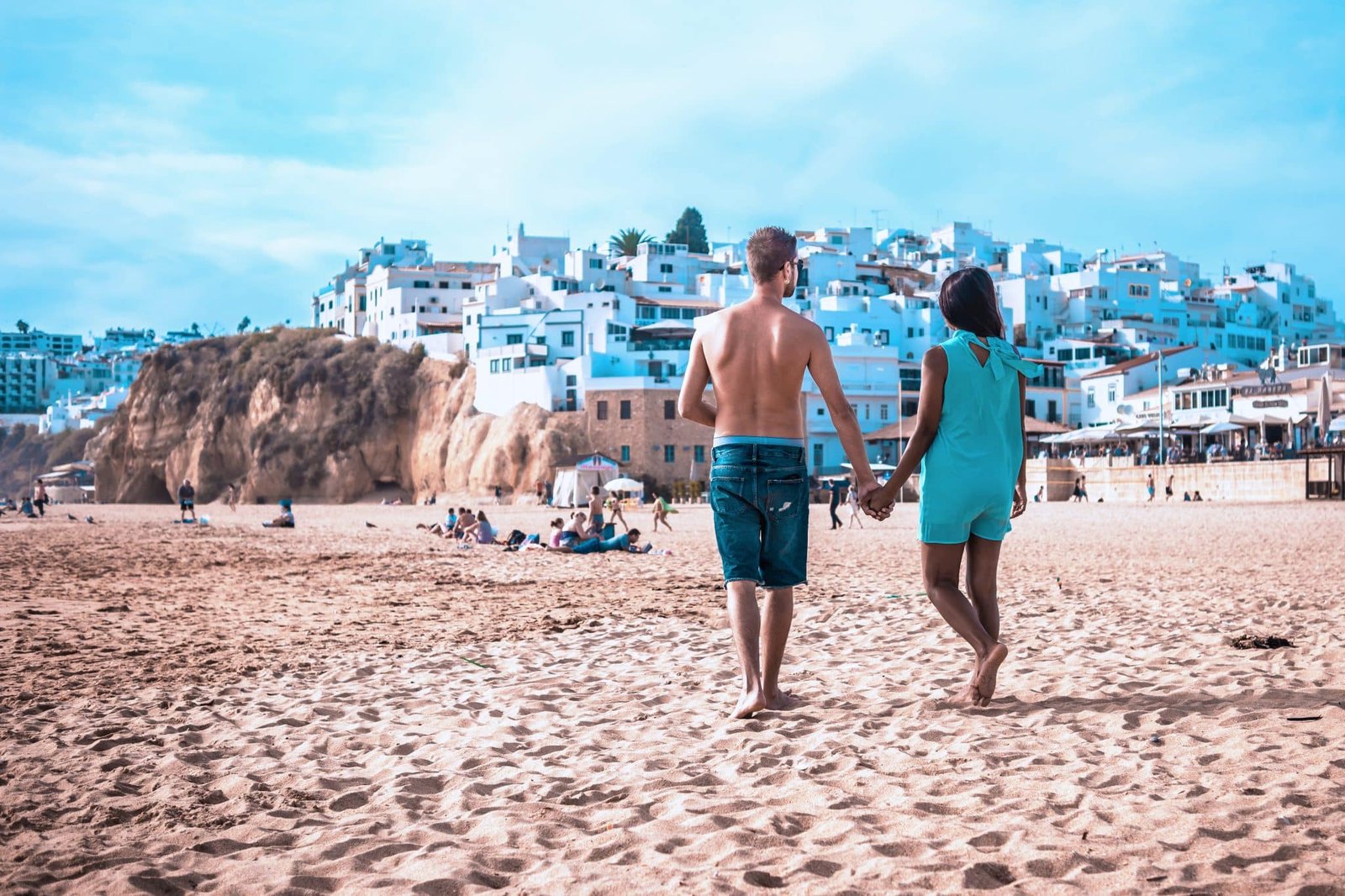 happy Young couple walking at the beach on the sand of Albufeira Algarve Portugal Algarve during summer