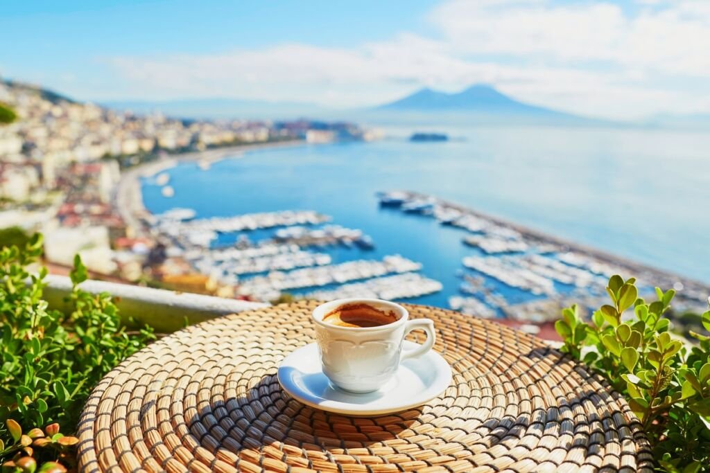 Cup of fresh espresso coffee in a cafe with view on Vesuvius mount in Naples, Campania, Southern Italy