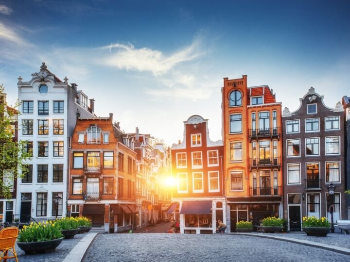 Beautiful tranquil sunset view of Amsterdam. Colorful houses in a terrace fashion in background