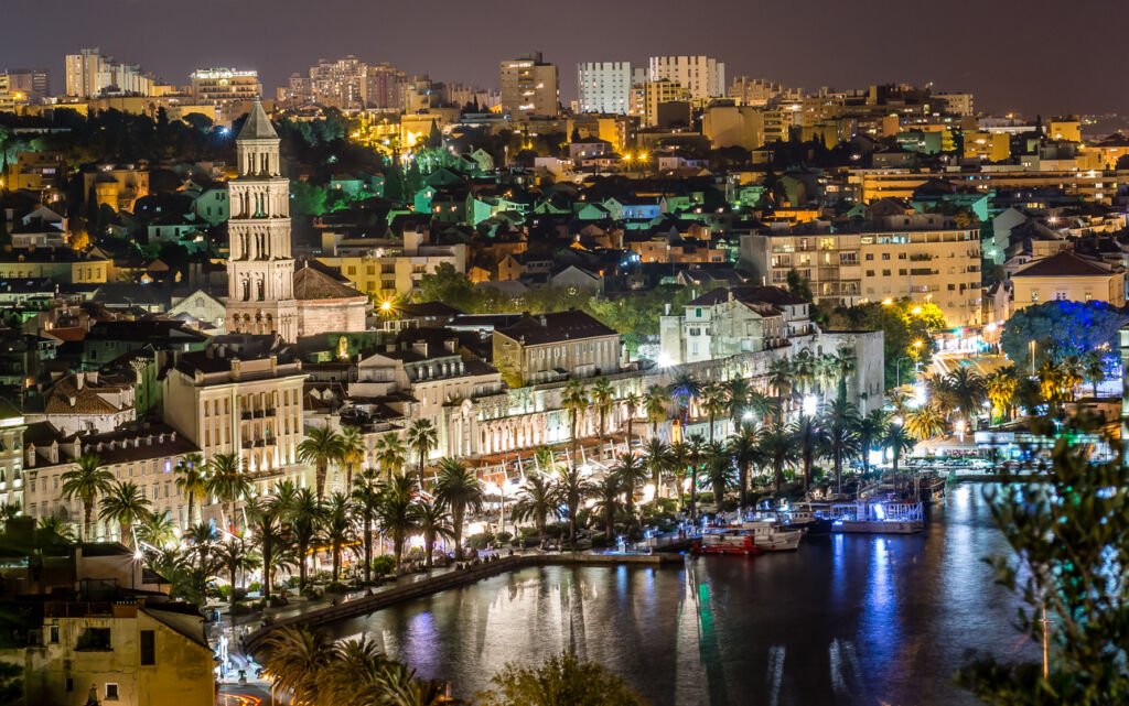Split's historic town at night: A labyrinth of narrow streets and ancient stone buildings, illuminated in a warm, golden glow, whispers tales of centuries past beneath the starry sky.