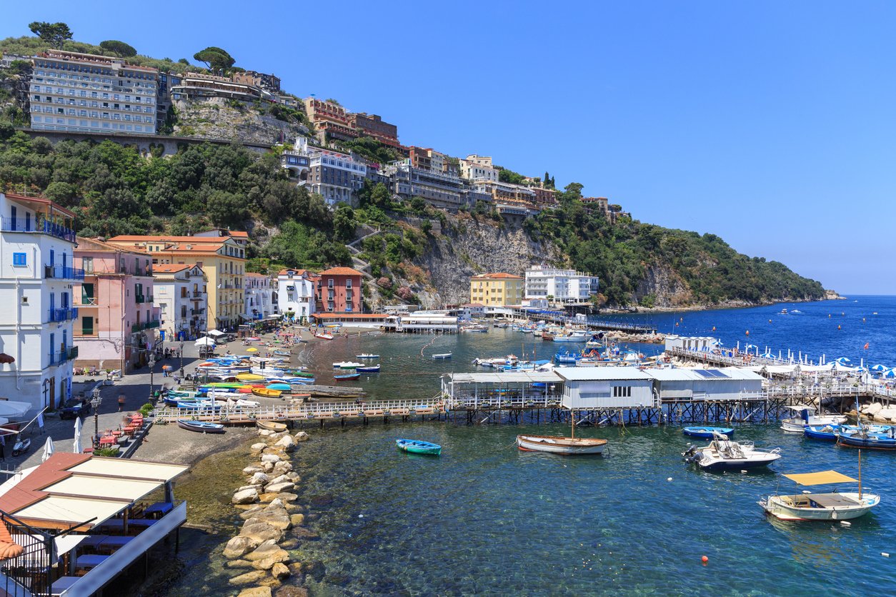 Sorrento's dock beckons with Mediterranean allure. Sunlit waves lap against the harbor, framing a timeless Italian town where the sea whispers tales of ancient charm and coastal enchantment.