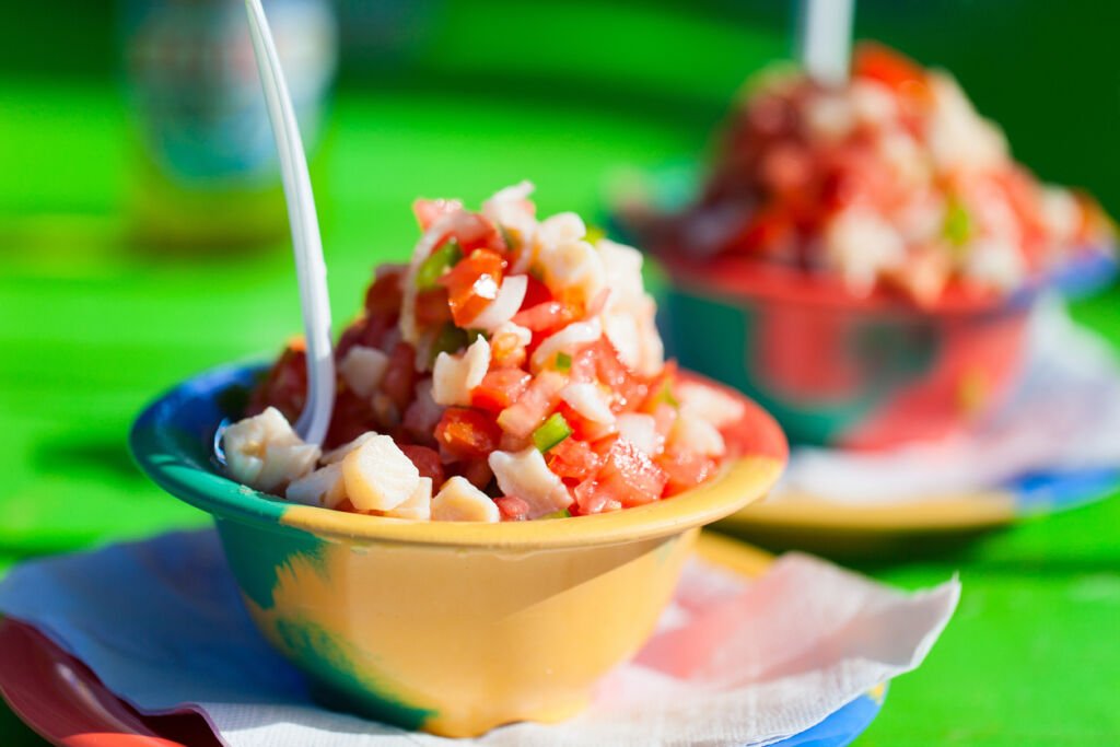 Two bowls of Bahamian conch salad, a tantalizing fusion of fresh conch, vibrant vegetables, and zesty citrus. A taste of the Bahamas captured in a colorful culinary masterpiece.