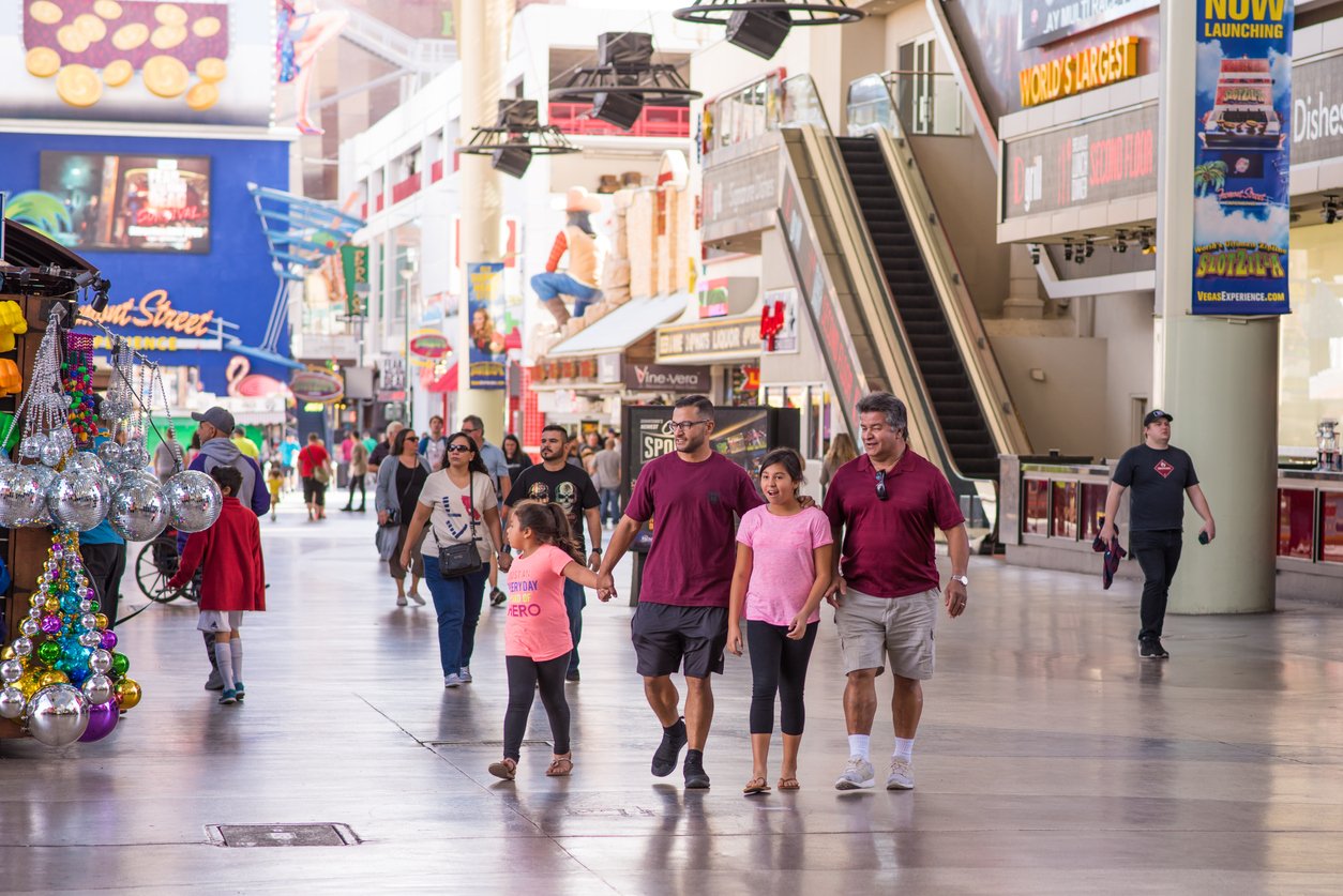"In downtown Las Vegas, a young family enjoys a day at the vibrant Fremont Street Experience. Amid historic sites, shopping, and dining, the area pulsates with energy, offering a diverse urban experience."