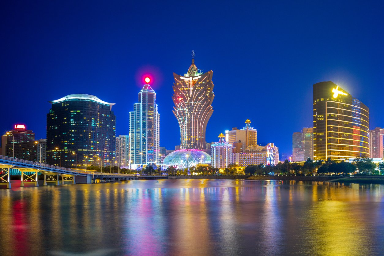 Macau's skyline by the sea emerges like a jewel at dusk. Glittering skyscrapers mirror in tranquil waters, as the fading sun paints the horizon with hues of amber and indigo.