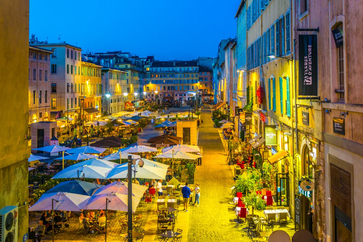 Marseille's Port Vieux square transforms at night, a culinary haven aglow. Restaurants lining the harbor beckon with warm lights, creating a picturesque scene of evening enchantment in southern France.