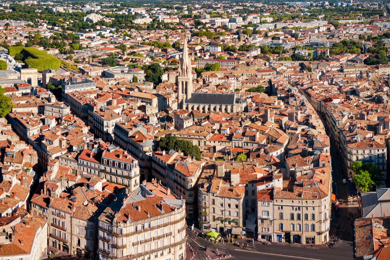 Montpellier unfolds like a vibrant tapestry below, its terracotta rooftops and historic landmarks embraced by lush greenery. The cityscape breathes life into the heart of southern France.