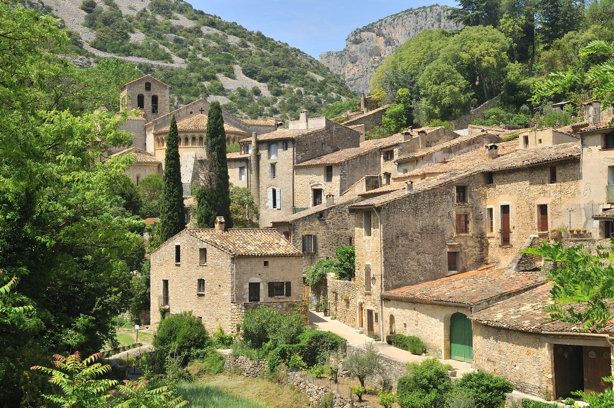 Saint-Guilhem-le-Désert captivates with medieval allure. Cobbled streets wind through honey-hued buildings, embraced by ancient stone walls. A picturesque haven near Montpellier, nestled in the sun-drenched South of France.
