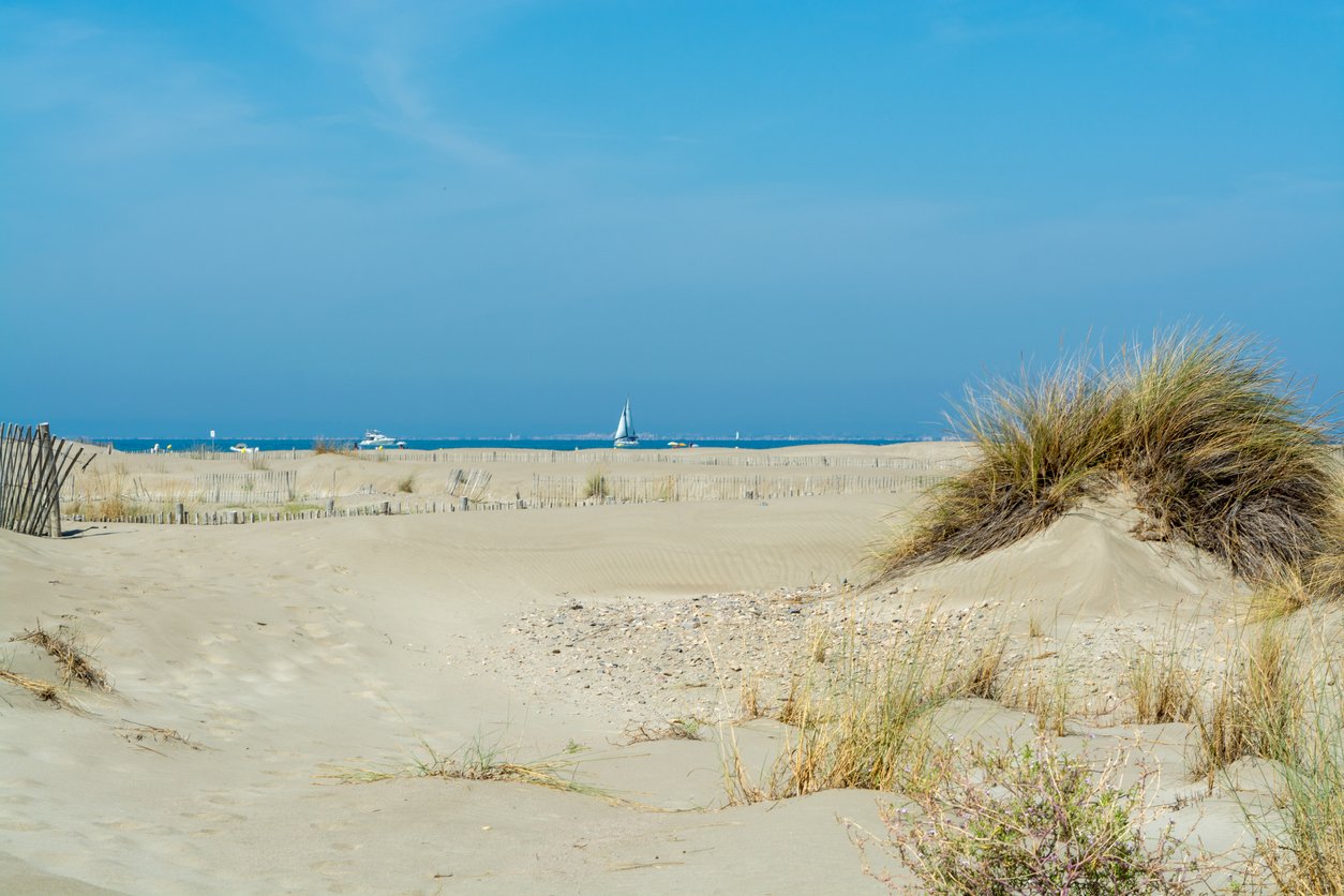 Plage de l'Espiguette, Le Grau du Roi, captivates with pristine white sands along France's Languedoc coast. The azure expanse meets endless shores, inviting tranquility beneath the radiant Mediterranean sun.