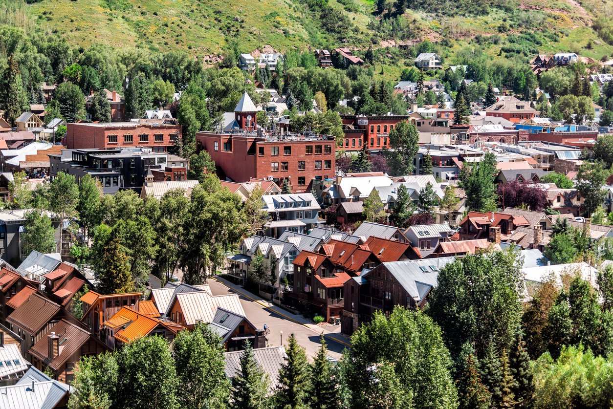 A bird's-eye view captures Telluride's small-town allure. Aerial and high-angle, the cityscape unfolds as the free gondola ascends to the mountain village, revealing the picturesque charm of summer in Colorado.