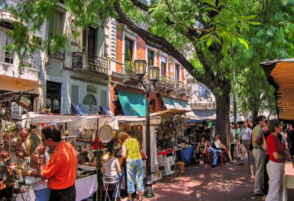 In Buenos Aires, Argentina, tourists explore the vibrant San Telmo flea market, a beloved attraction in the old town. The market buzzes with activity as visitors discover unique treasures amid the historic charm.