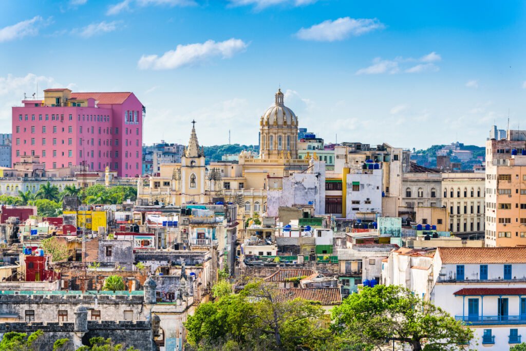 The vibrant Havana downtown skyline dazzles with colorful colonial buildings, framed by the azure Caribbean sea, and punctuated by iconic landmarks like the Capitolio.